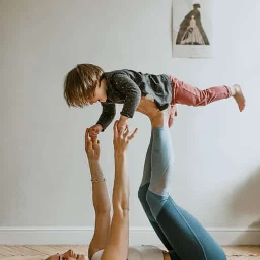Madre practicando yoga con su hijo durante un taller de yoga para mamás y peques enfocado en movimiento y vínculo.
