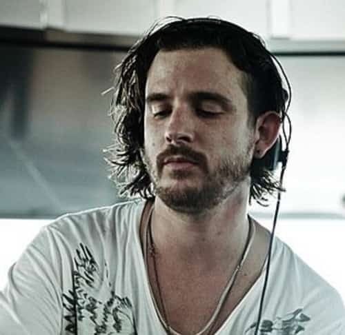 Luciano actuando en directo; fundador de Cadenza y creador de Vagabundos; DJ de minimal/house con percusión latina, primer plano con público nocturno.