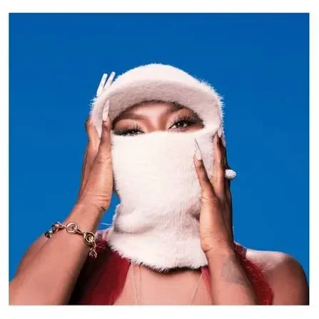Retrato de Aya Nakamura con accesorio de pelo rosa sobre fondo azul, fotografía artística de la cantante franco-maliense.