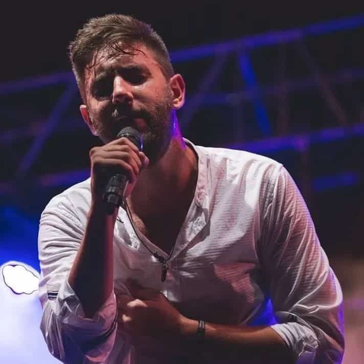 Singer performing live with a microphone on stage, ideal for showing energy, closeness and live music atmosphere.