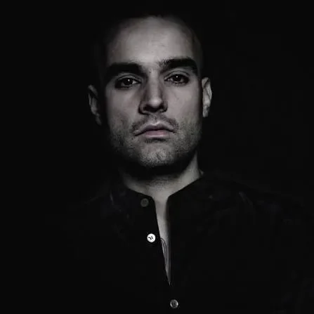 Retrato en blanco y negro de Paco Osuna sobre fondo oscuro, fotografía de perfil del DJ y productor español de techno.
