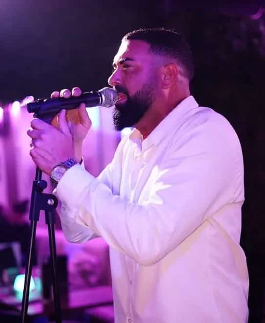 Rubén Fernández singing live with a microphone in a night-time setting, ideal for live music, fairs and social events.