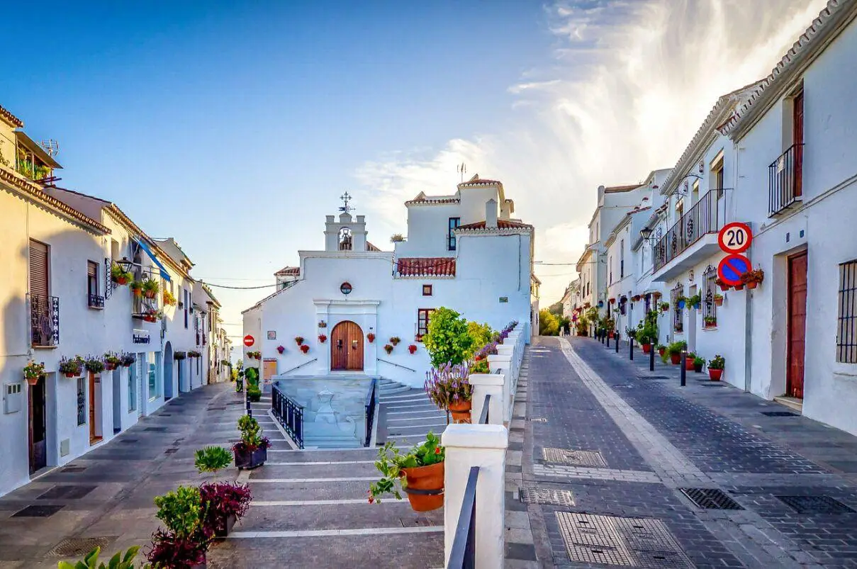 Panoramic view of Mijas Pueblo, a traditional Andalusian white village with flower-decorated streets and sea views.