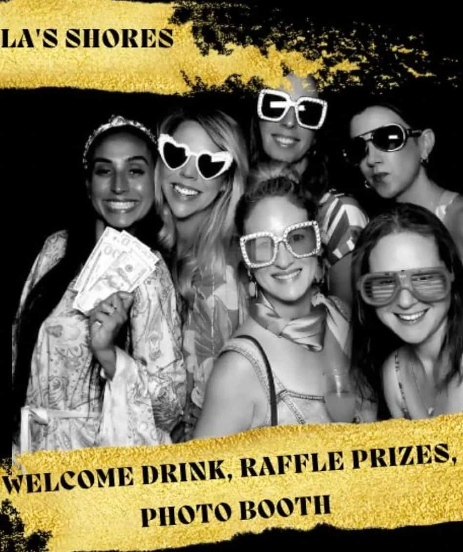 Group of women posing together in a glamorous photo booth setup at an Afternoon Divas event, wearing fun statement sunglasses and smiling, with gold and black party-themed graphics highlighting welcome drinks, raffle prizes, and a photo booth experience.