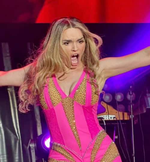 Concert poster for Melody stating “Sunday 19 — 11:00 PM — Fairgrounds Auditorium (La Caridad),” fair-style artwork with bold titles.