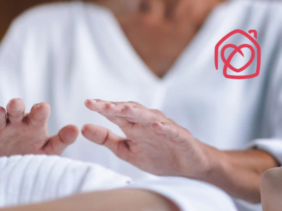 Sesión de reiki para adultos en Casa Ángeles Marbella, terapeuta aplicando terapia energética con manos sobre el cuerpo en ambiente relajante de bienestar y equilibrio emocional.