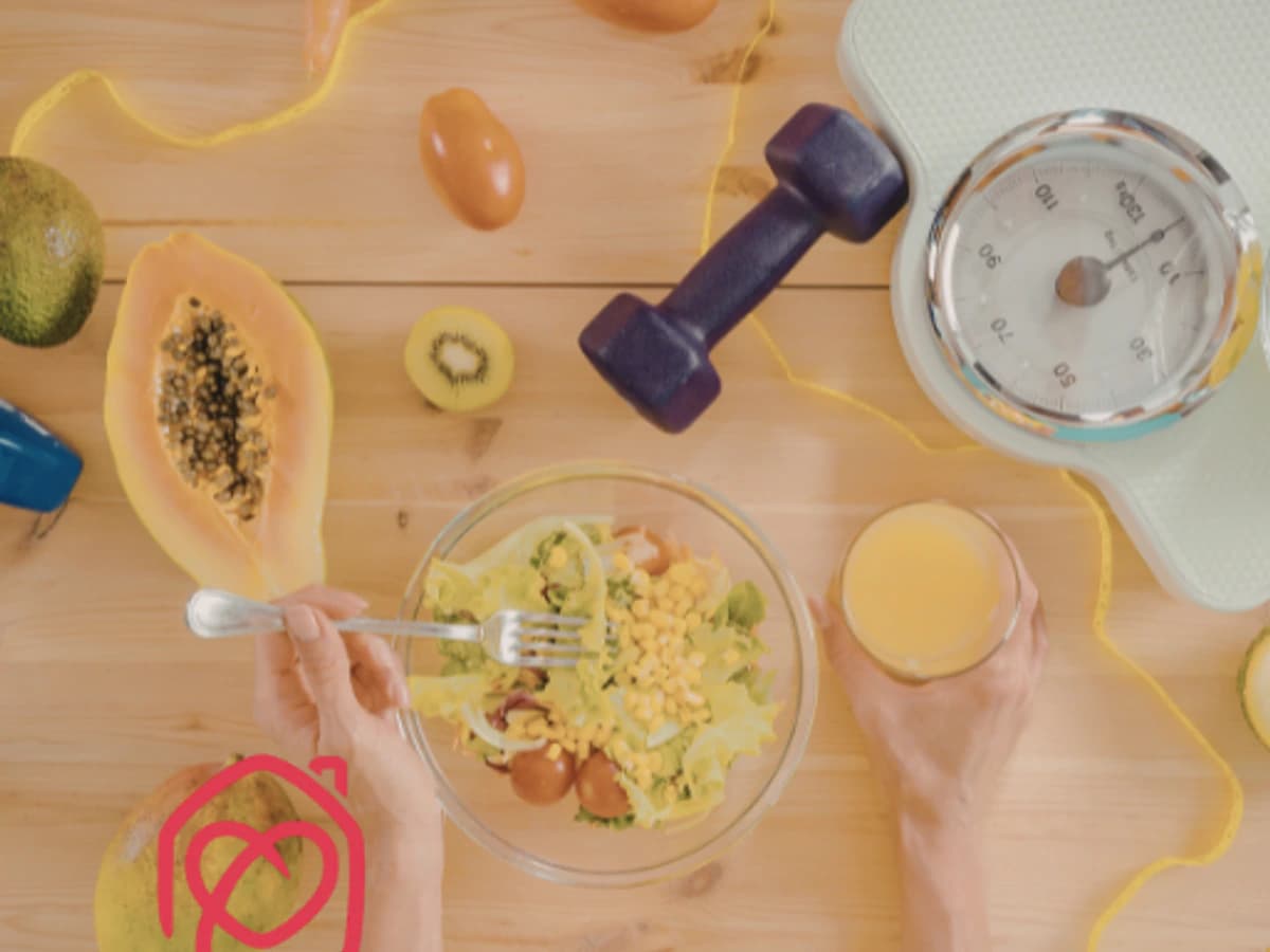 Imagen cenital de alimentación saludable con ensalada, frutas, báscula y material deportivo, representando hábitos saludables y nutrición consciente. Fotografía asociada a taller de nutrición infantil en Marbella, enfocada en bienestar, salud familiar, alimentación equilibrada y estilo de vida saludable.