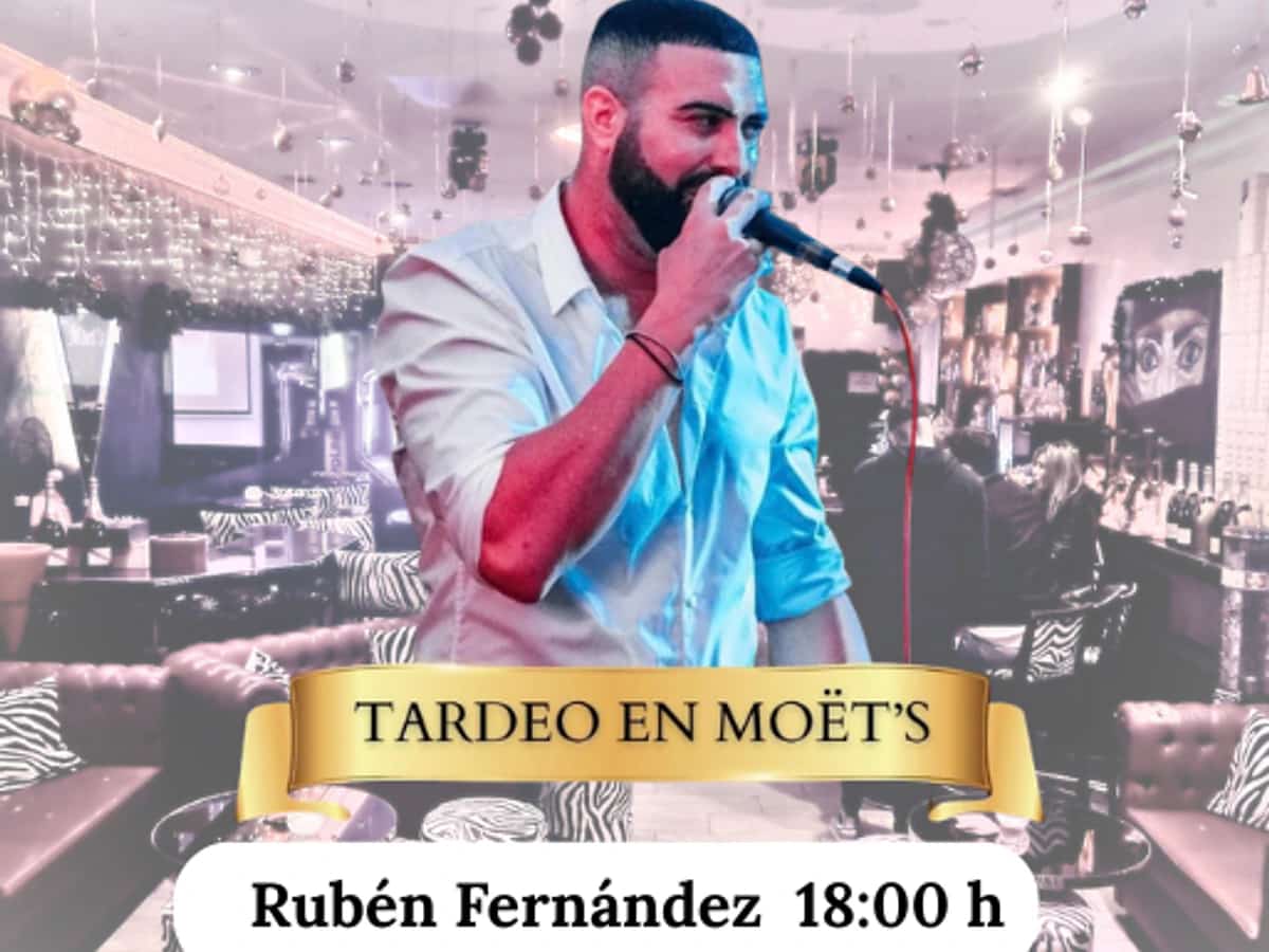 Rubén Fernández cantando en directo durante un tardeo en Moët’s, con micrófono en mano y el interior del local al fondo.