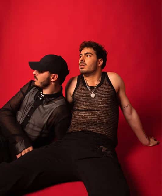 Gemeliers actuando en vivo con luces de escenario vibrantes