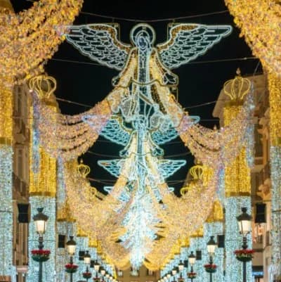 Espectacular iluminación navideña con ángeles y cortinas de luces en una gran avenida, típica de la Navidad en la Costa del Sol cerca de Marbella.