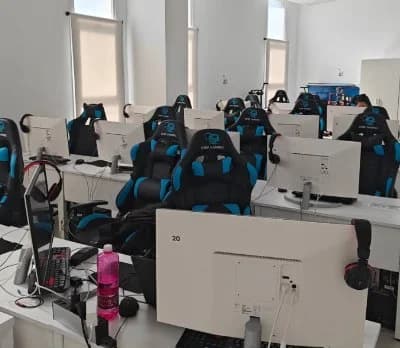 Aula tecnológica con PCs y sillas gaming para talleres e IA del StartUps Festival Marbella 2025, hackathon turístico en la Costa del Sol.