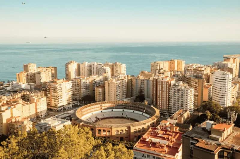 Vista panorámica de Málaga Centro con la plaza de toros de La Malagueta, edificios urbanos y el mar Mediterráneo al fondo.