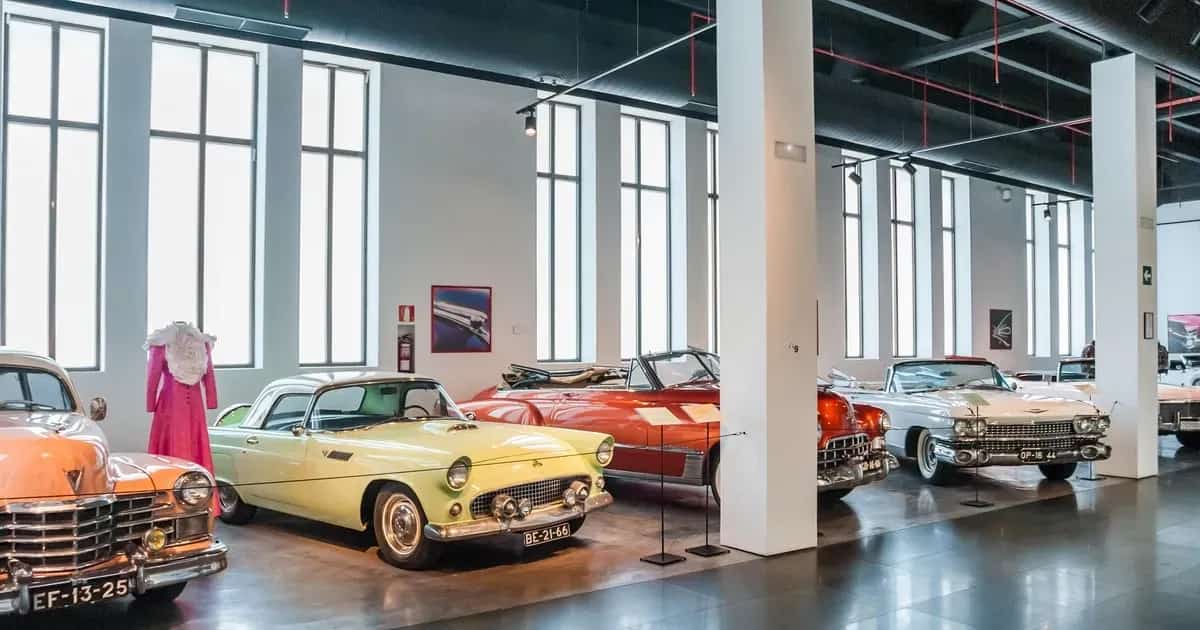 Vista interior del Museo Automovilístico de Málaga, que muestra coches clásicos y exposiciones de moda dentro del salón de techos altos del antiguo edificio de la Fábrica de Tabacos.