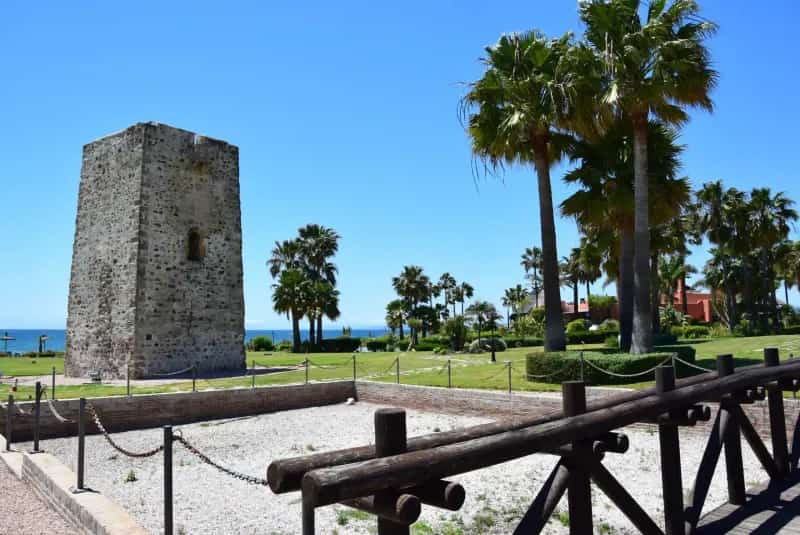 Torre de Guadalmansa rodeada de palmeras y jardines junto al mar en el Parque de Cabo Bermejo, Estepona.