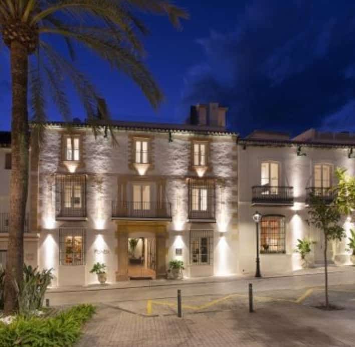 Night view of La Fonda Heritage Hotel on Plaza Santo Cristo in Marbella’s Old Town with elegant architectural lighting.